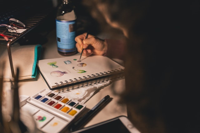 Fotografía de una persona dibujando en un cuaderno. 